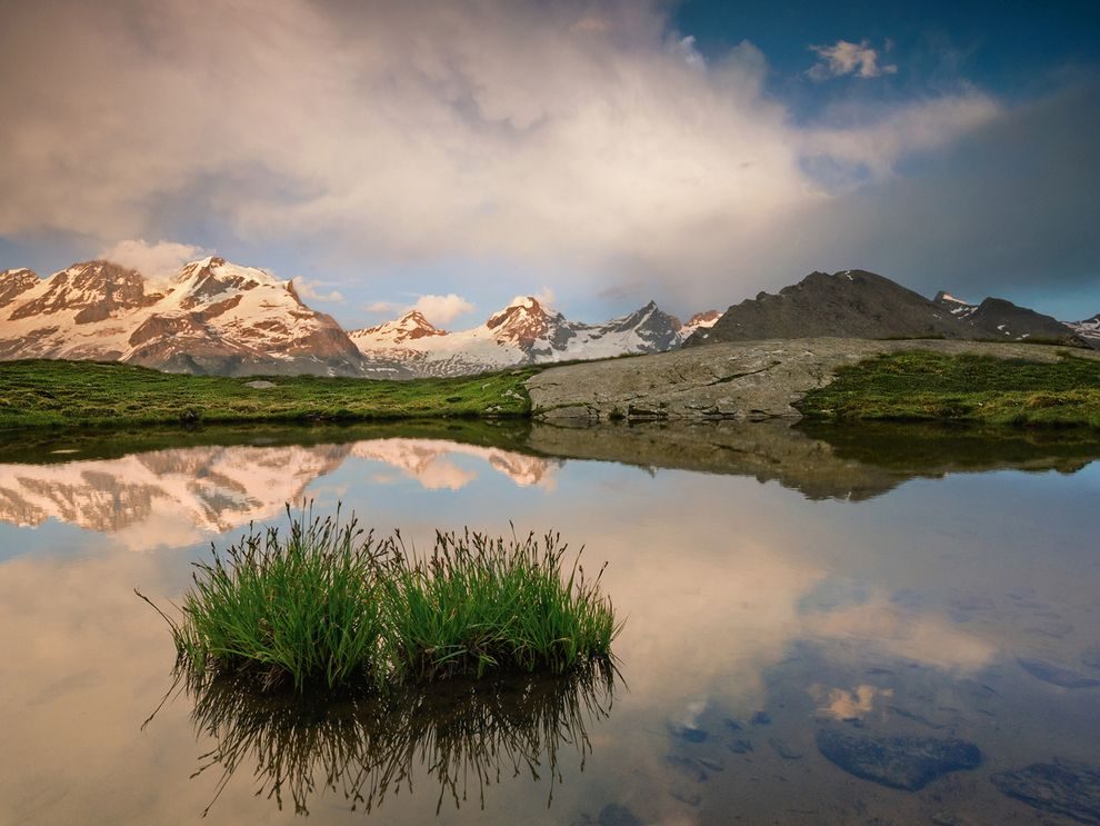 Picture of the peaks of Gran Paradiso reflected in a still lake in Italy